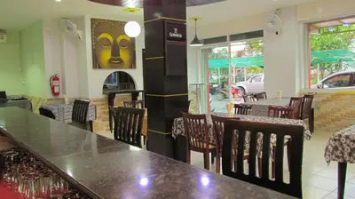 a restaurant with a table and chairs in a room at La Piccola Patong in Patong Beach