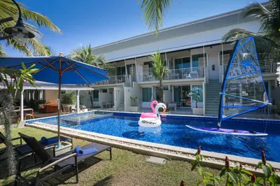 a pool in front of a house with a swan in the water at Impress Resort in Thalang