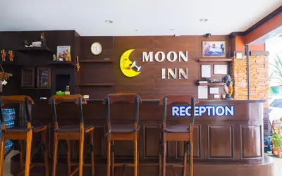 a restaurant with a bar with chairs and a moon inn registration at Patong Moon Inn Residence in Patong Beach