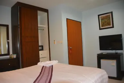 a bedroom with a bed and a tv and a mirror at Patong Moon Inn Residence in Patong Beach
