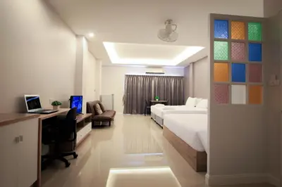 a bedroom with a bed and a desk with a computer at Vipa House Phuket - SHA Extra Plus in Chalong