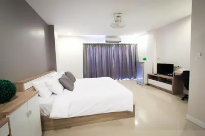a bedroom with a white bed and a television at Vipa House Phuket - SHA Extra Plus in Chalong