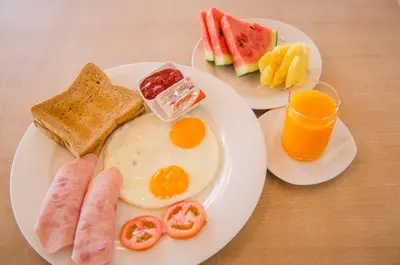 two plates of breakfast foods on a table at Casa Bella Phuket in Chalong