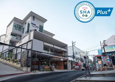 a man walking down a street in front of a building at OneLoft Hotel in Karon Beach