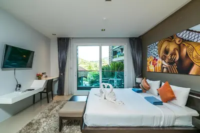a bedroom with a large bed and a large window at Emerald Terrace Apartments by Lofty in Patong Beach