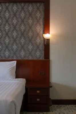 a bedroom with a bed and a table with a lamp at Erawan Phangnga Hotel, Natai Beach in Khok Kloi