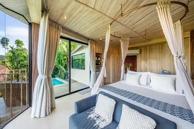 a bedroom in a villa with a bed and a balcony at Sametnangshe Boutique in Phangnga