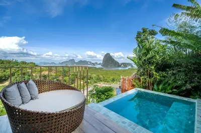 a wicker chair sitting on a deck next to a swimming pool at Sametnangshe Boutique in Phangnga