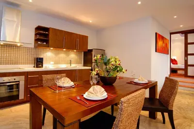 a kitchen with a wooden table and some chairs at Villa Susu by Holiplanet in Rawai Beach