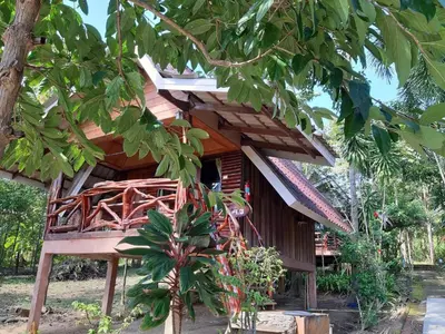 a tree house with a bed in front of it at Activities Resort in Ko Yao Yai