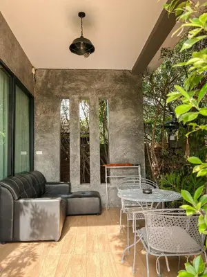 a patio with a couch and a table and chairs at BaanMee Phuket near Chalong Pier in Chalong