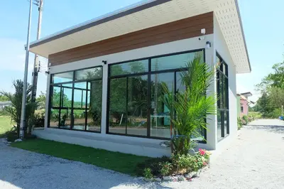 a building with large windows on the side of it at Maikhao Beach Guest House in Mai Khao Beach