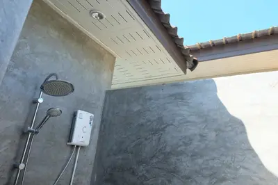 a shower in a bathroom with a shower head at Maikhao Beach Guest House in Mai Khao Beach