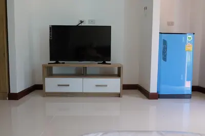 a flat screen tv sitting on top of a entertainment center at Maikhao Beach Guest House in Mai Khao Beach