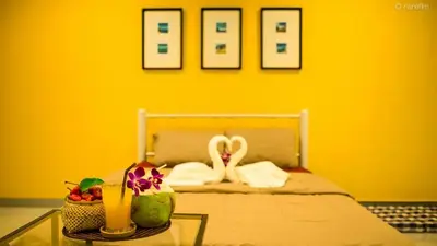 a yellow room with a bed with a yellow wall at Vii House Rawai Phuket in Rawai Beach