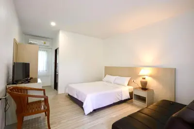 a bedroom with a white bed and a couch at Fantasy Hill Bungalow in Kata Beach