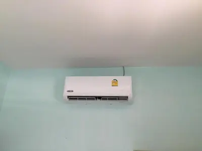 a white air conditioner on a blue wall at Fantasy Hill Bungalow in Kata Beach