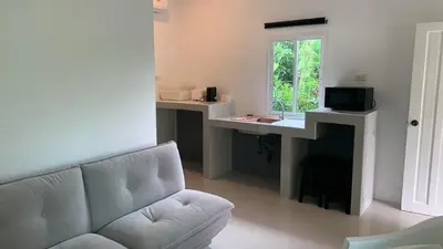 a living room with a couch and a window at Fantasy Hill Bungalow in Kata Beach