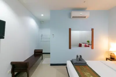 a bedroom with a bed and a mirror on the wall at Chaiyo Resort in Phuket Town