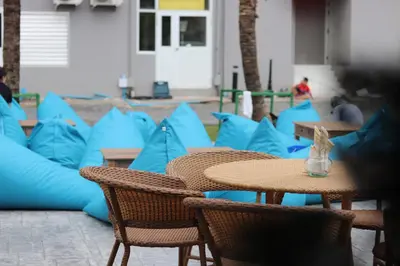 a group of tables and chairs with blue pillows at Panphuree Residence in Nai Yang Beach
