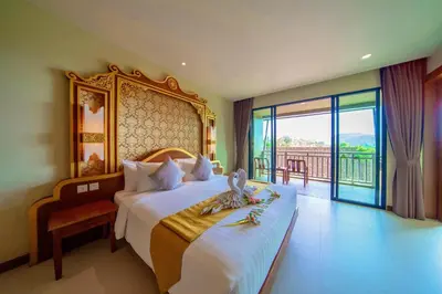 a hotel room with a bed and a balcony at Maikhao Palm Beach Resort - SHA Plus in Mai Khao Beach