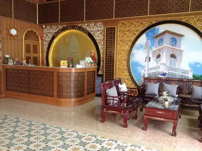 a lobby with chairs and a clock on the wall at Phuket Chinoinn-SHAPlus Certified in Phuket Town