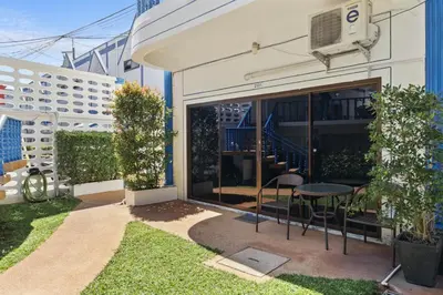 a patio with a table and chairs in front of a building at The Club Residence Kamala Beach in Kamala Beach