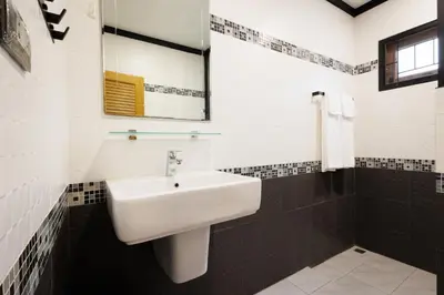 a bathroom with a sink and a mirror at T House in Bang Tao Beach