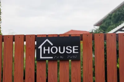 a sign for a house on a fence at T House in Bang Tao Beach