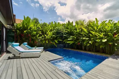 a deck with a bench and a swimming pool at Inspire Villas Phuket in Rawai Beach