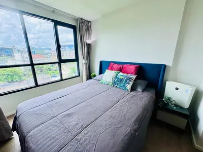 a bedroom with a large bed with a large window at Centrio nearby Central Phuket in Phuket Town