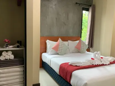 a bedroom with a bed with two towels on it at Isayarada Apartment in Thalang
