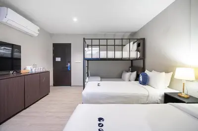 a bedroom with two beds and a flat screen tv at Kokotel Phuket Patong in Patong Beach