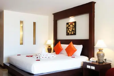 a bedroom with a bed with orange and white pillows at Baan Yuree Resort & Spa - SHA Plus in Patong Beach