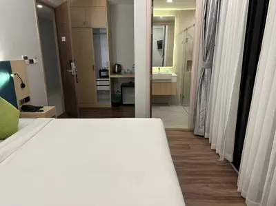 a bedroom with a white bed and a bathroom at Baan Yuree Resort & Spa - SHA Plus in Patong Beach