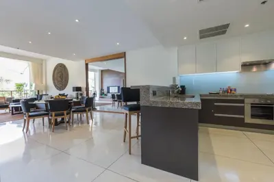 a kitchen and dining room with a table and chairs at The Chava Resort in Surin Beach