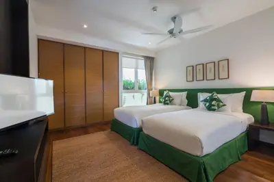 a bedroom with two beds and a television in it at The Chava Resort in Surin Beach
