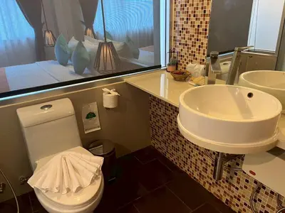 a bathroom with a white toilet and a sink at MORE Patong Hotel in Patong Beach