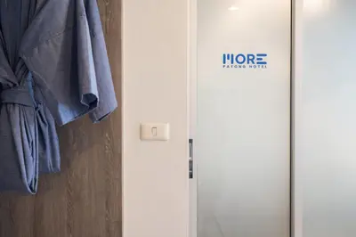 a door with the word more hanging on it at MORE Patong Hotel in Patong Beach