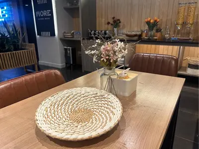 a wooden table with a vase of flowers on it at MORE Patong Hotel in Patong Beach