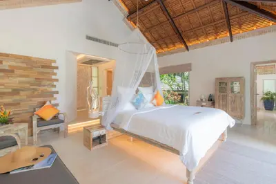 a bedroom with a bed and a desk and a chair at Paradise Koh Yao in Ko Yao Noi