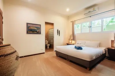 a bedroom with a bed and a large window at Chaba Pool Villa Private Tropical Villa With Pool in Nai Harn Beach