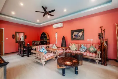a living room with orange walls and couches at Chaba Pool Villa Private Tropical Villa With Pool in Nai Harn Beach
