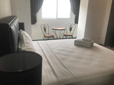 a large white bed with chairs and a table at Cafe de Paris in Patong Beach