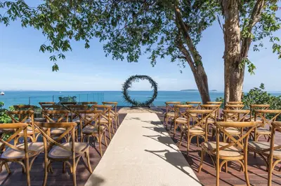 a wedding ceremony setup at the beach with a wedding arch at Cape Panwa Hotel Phuket in Panwa Beach