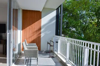 two chairs sitting on the porch of a house at Cape Panwa Hotel Phuket in Panwa Beach