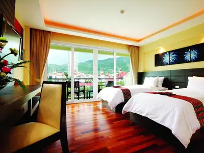 a hotel room with two beds and a balcony at R-Mar Resort and Spa Patong, Phuket in Patong Beach