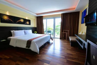 a hotel room with a bed and a balcony at R-Mar Resort and Spa Patong, Phuket in Patong Beach