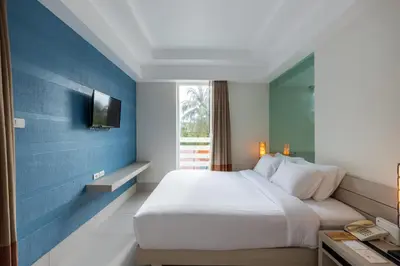 a bedroom with a white bed and a blue wall at Navinda Krabi in Ao Nang Beach