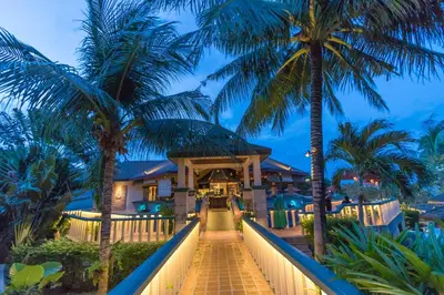 a resort with palm trees and a walkway at Mangosteen Ayurveda & Wellness Resort - SHA Plus in Rawai Beach